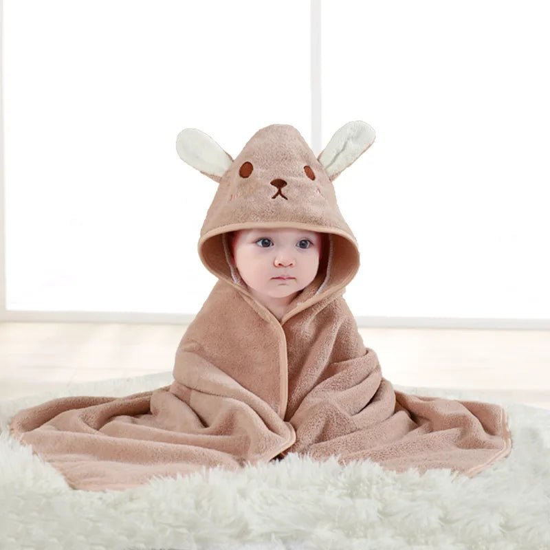 Baby wrapped in a brown hooded towel with bunny ears on a white background