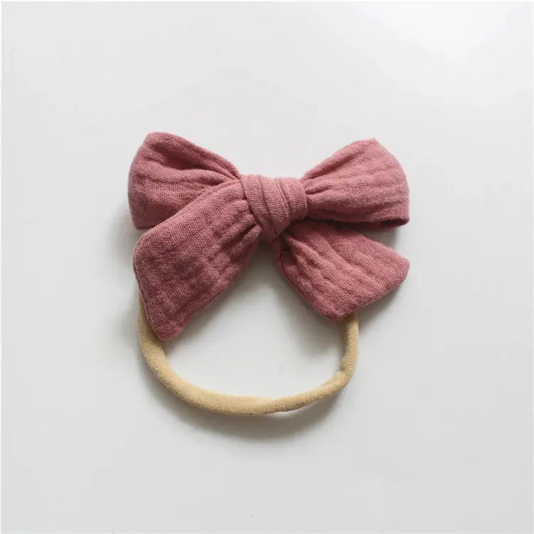 Pink bow headband on a light gray background