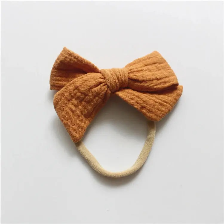 Orange bow headband on a light gray background