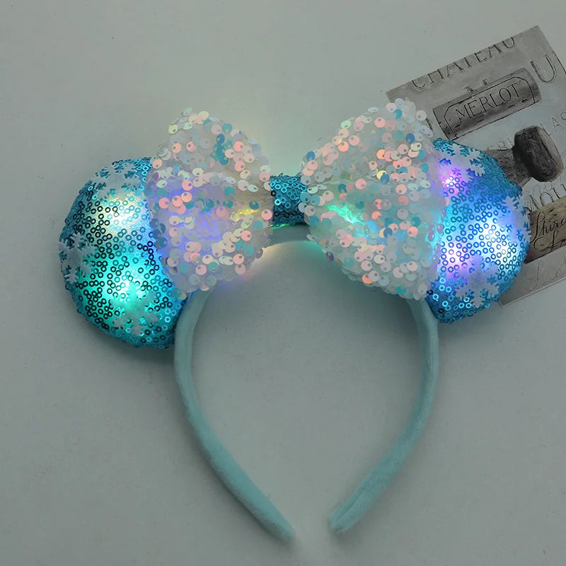Sparkly blue and white headband with bow on a light gray background