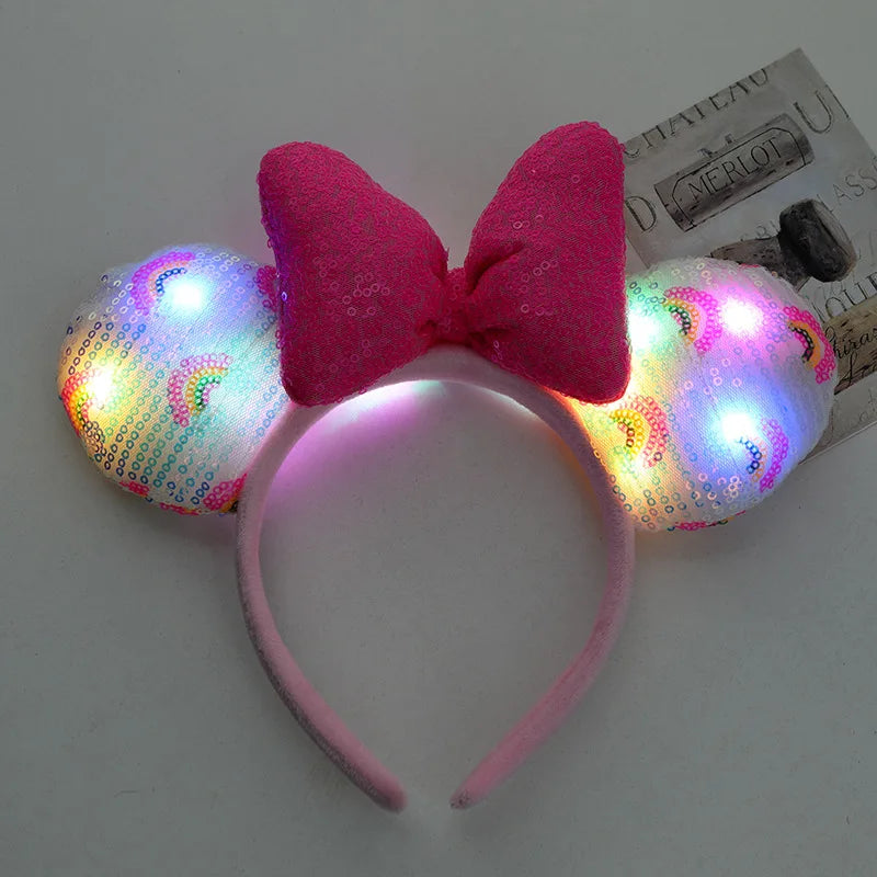 Pink LED mouse ears headband with a bow on a white background