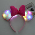 Pink LED mouse ears headband with a bow on a white background