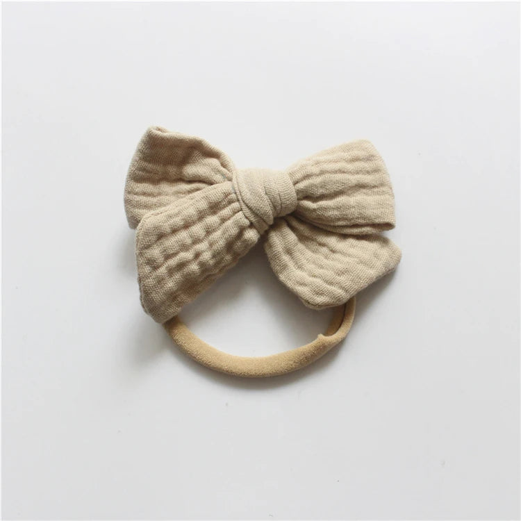 Beige knitted bow headband on a light gray background