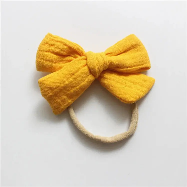 Yellow bow hair accessory on a white background
