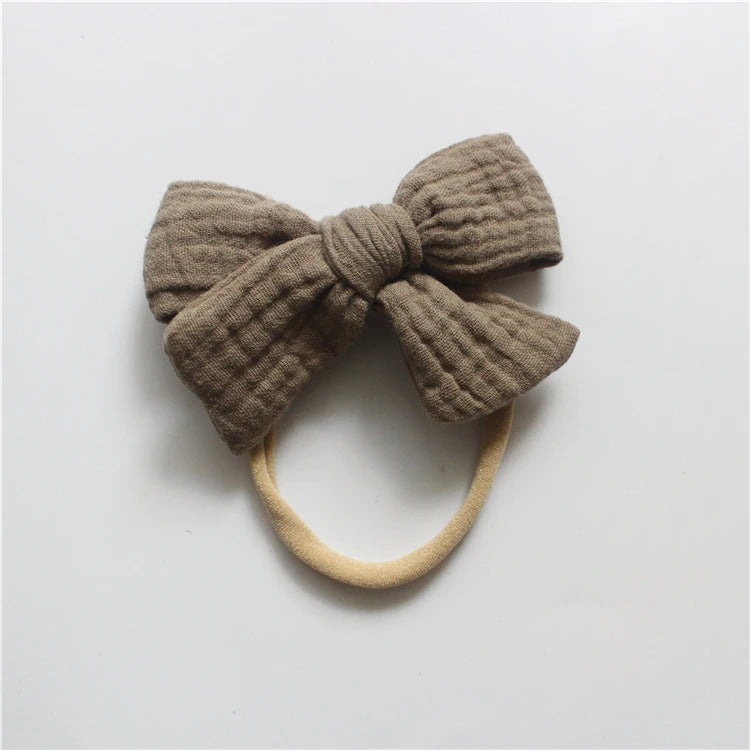Brown knitted bow headband on a white background