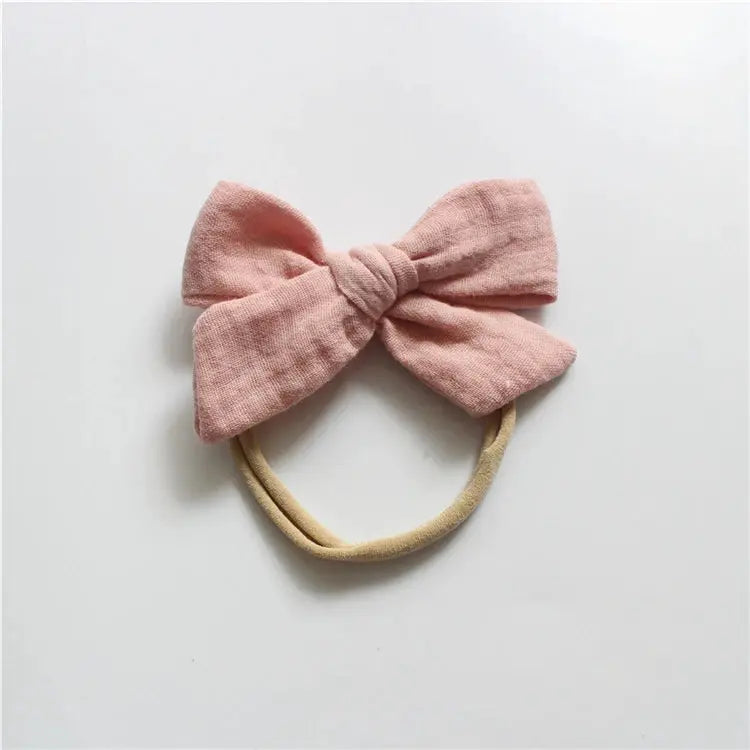 Pink bow headband on a light gray background