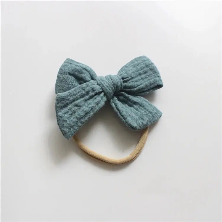 Blue bow headband on a light gray background