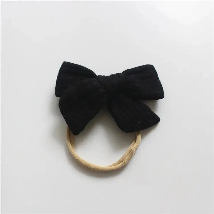 Black bow hair tie on a white background