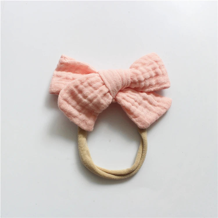 Pink bow-shaped headband on a light gray background