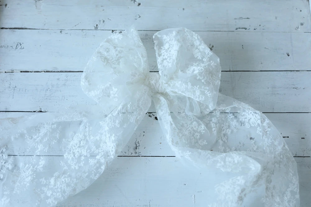 White lace bow on a wooden surface