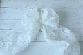 White lace bow on a wooden surface