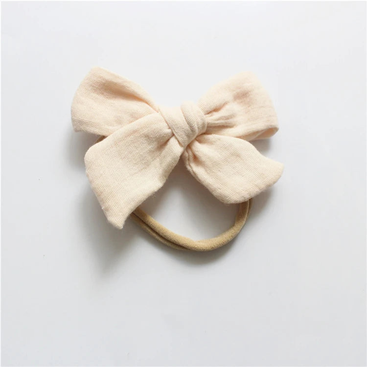 Beige bow hair accessory on a light gray background