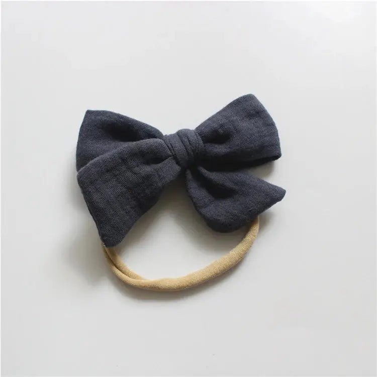 Navy blue bow hair accessory on a light gray background