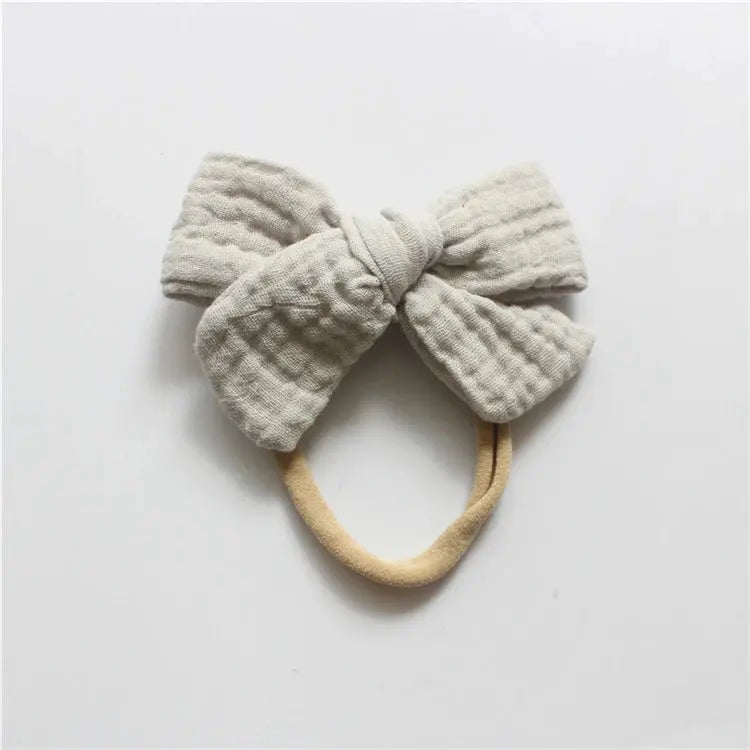 Textured bow headband on a light gray background