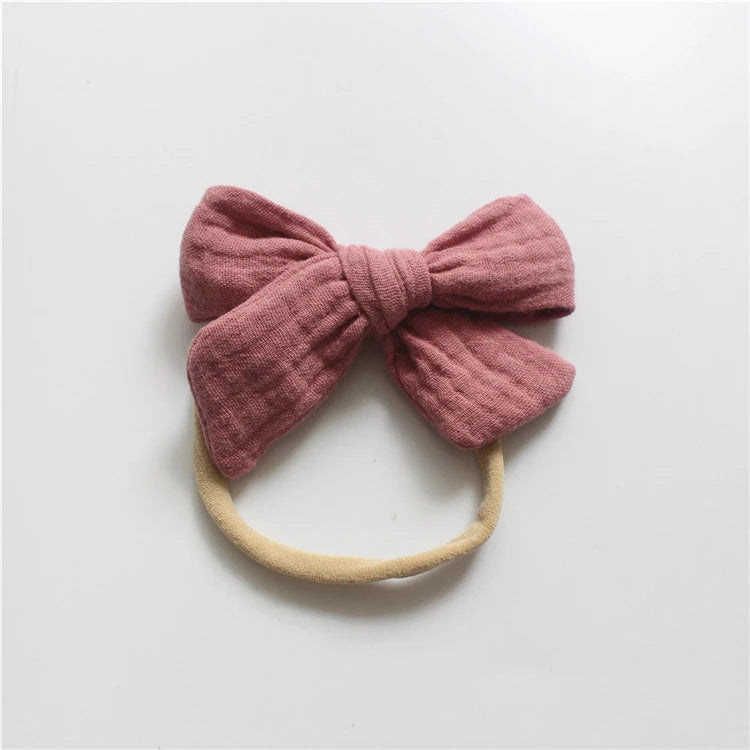 Pink bow headband on a light gray background