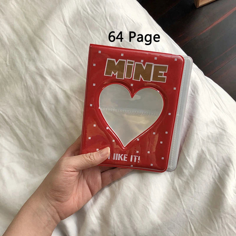 Red photo album with a heart design held by a hand on a white surface