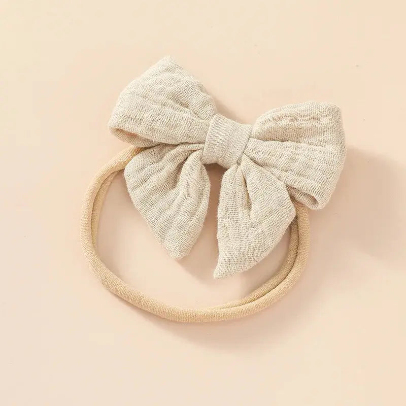 Beige headband with a large bow on a beige background