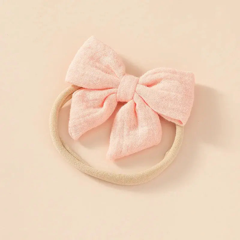Pink bow headband on a beige background