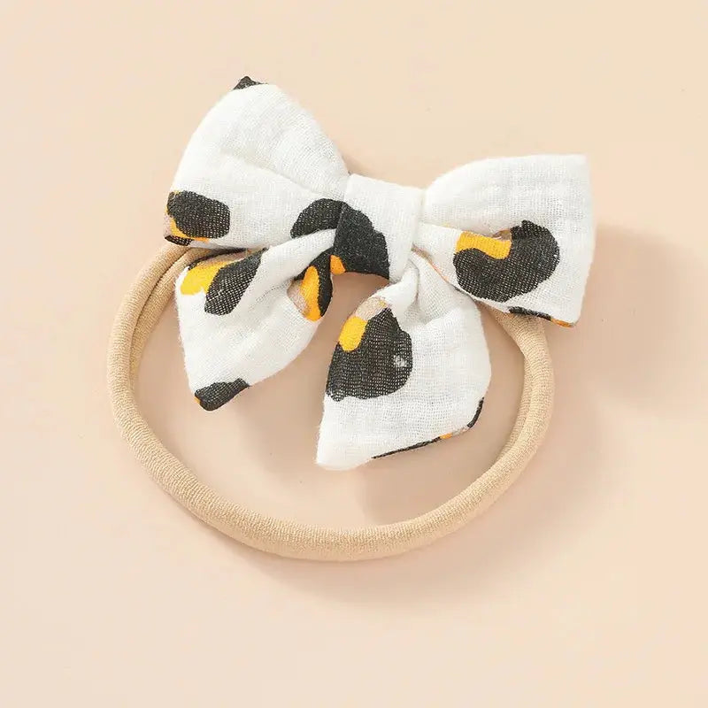White bow with black and yellow accents on a beige background