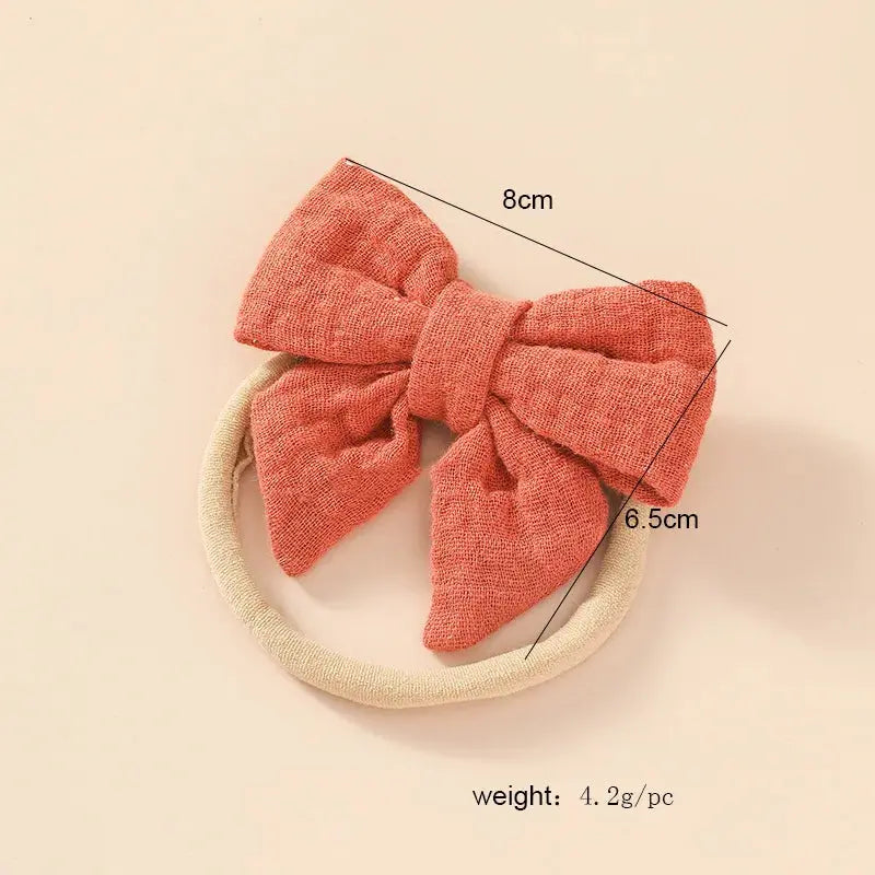 Red bow hairband with measurements on a beige background