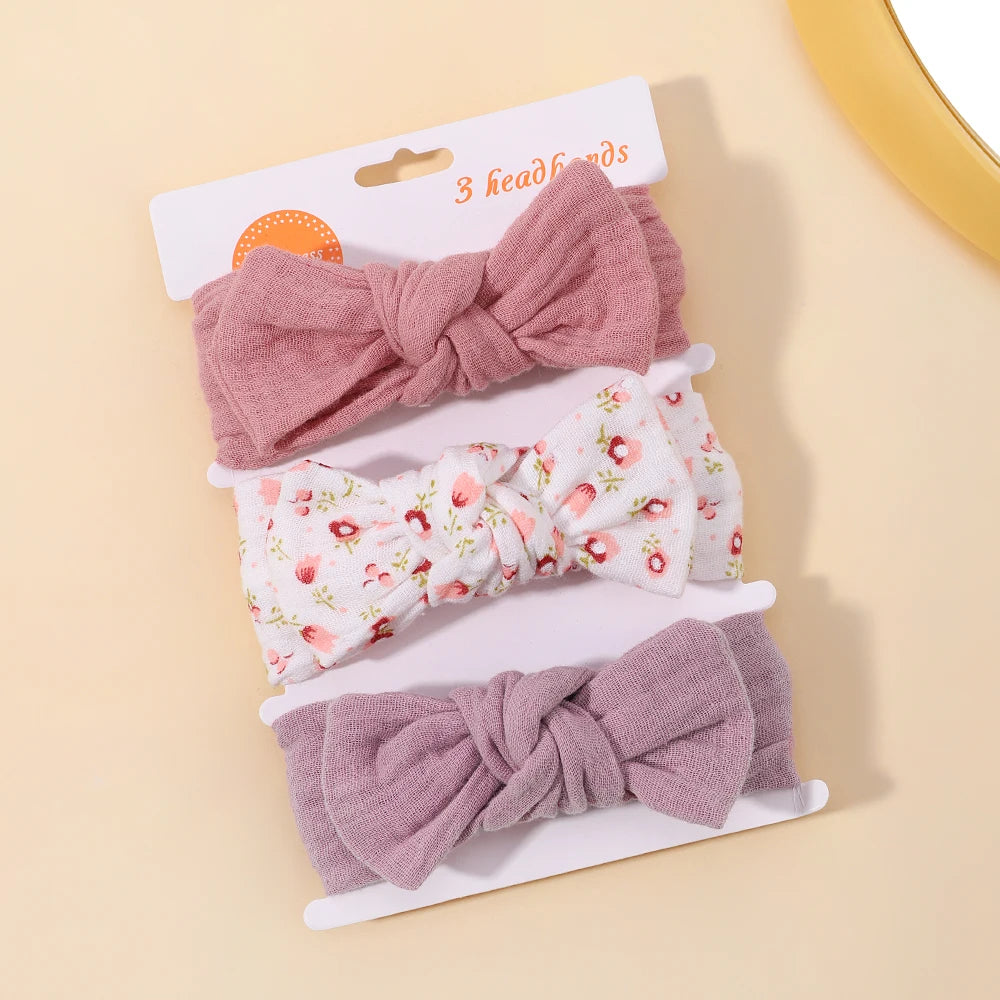 Set of three headbands with floral and solid designs on a beige background