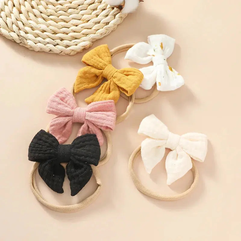 Set of colorful bow hairbands on a beige surface