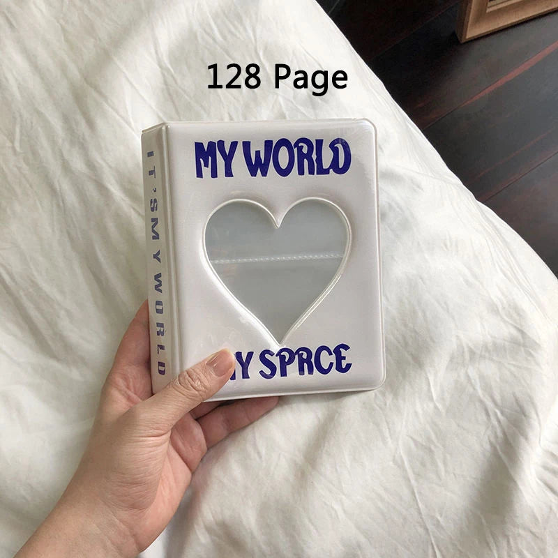 Photo album titled 'My World My Space' with a heart cutout held by a hand on a white surface.
