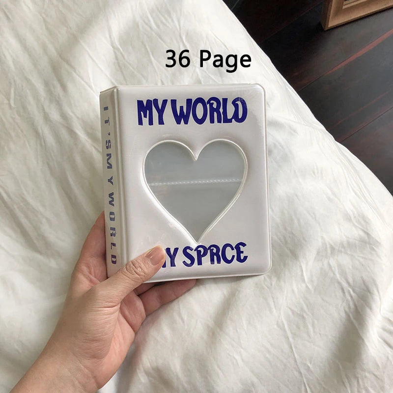 Photo album titled 'My World My Space' with a heart cutout held by a hand on a white surface.