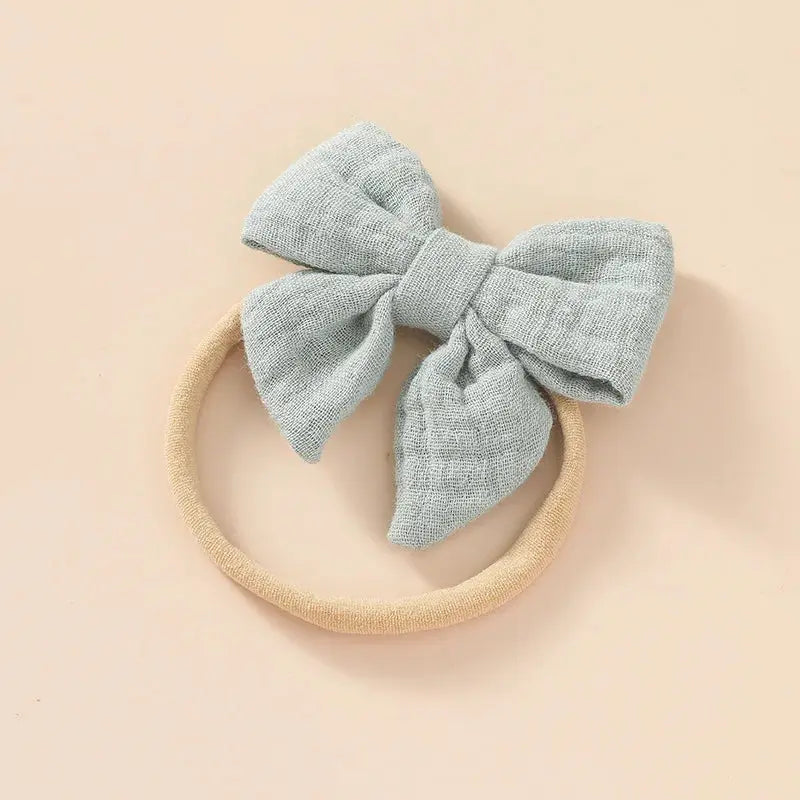 Light blue bow headband on a beige background