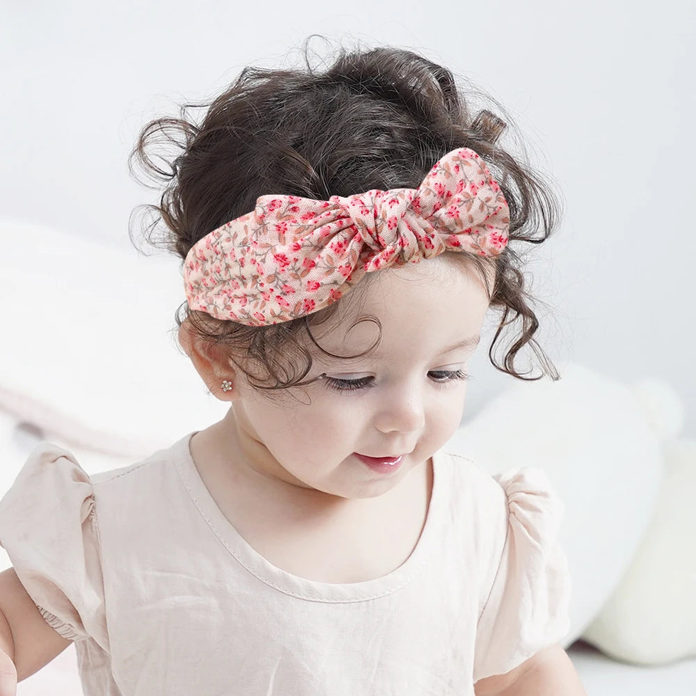 Child wearing a floral headband with a white background