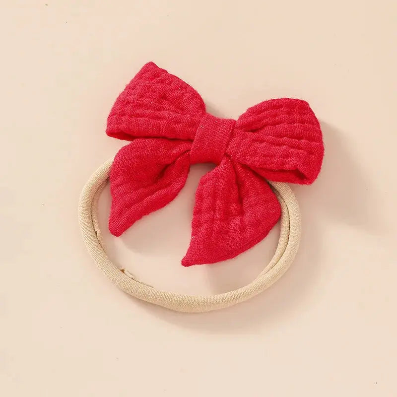 Red bow headband on a beige background