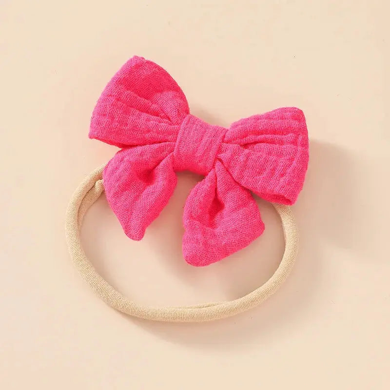 Pink bow headband on a beige background