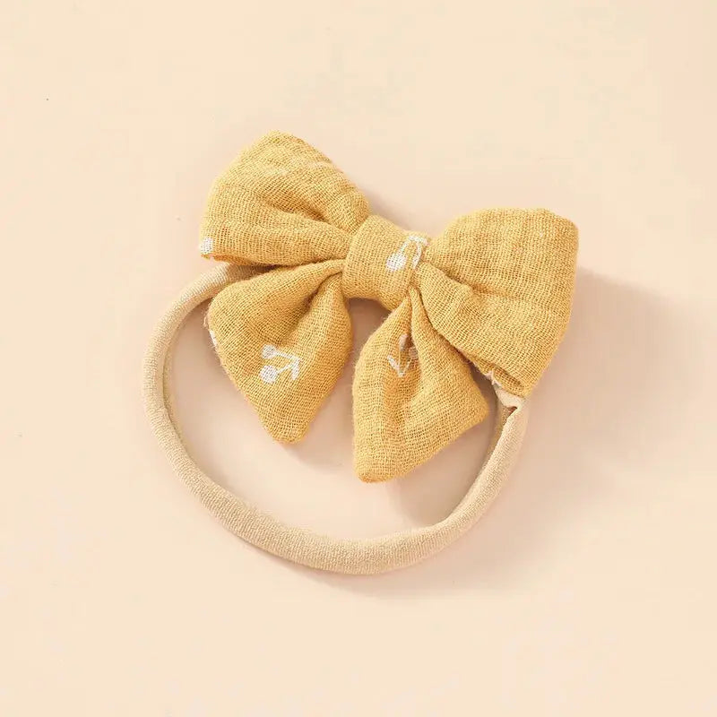 Yellow bow headband on a beige background