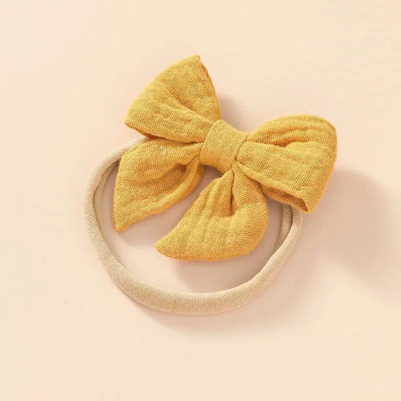 Yellow bow headband on a beige background