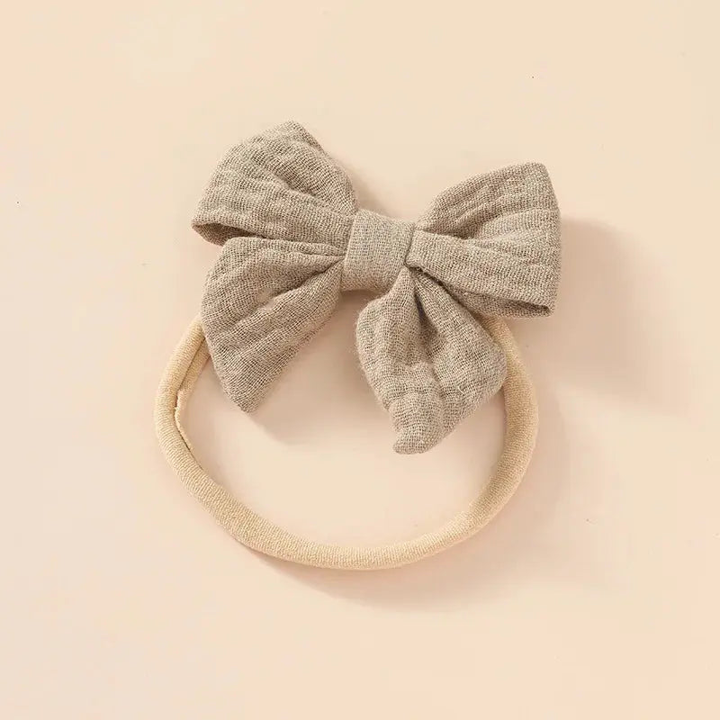 Gray bow headband on a beige background