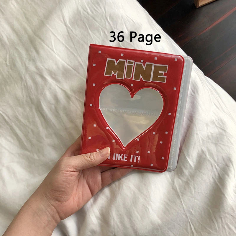 Red photo album  with a heart design held by a hand on a white surface