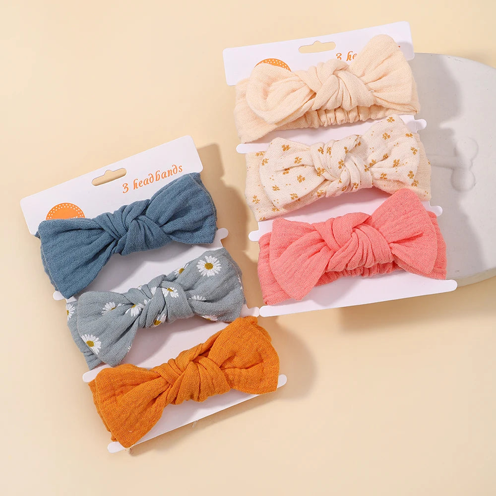 Set of colorful bow hairbands on packaging with a beige background