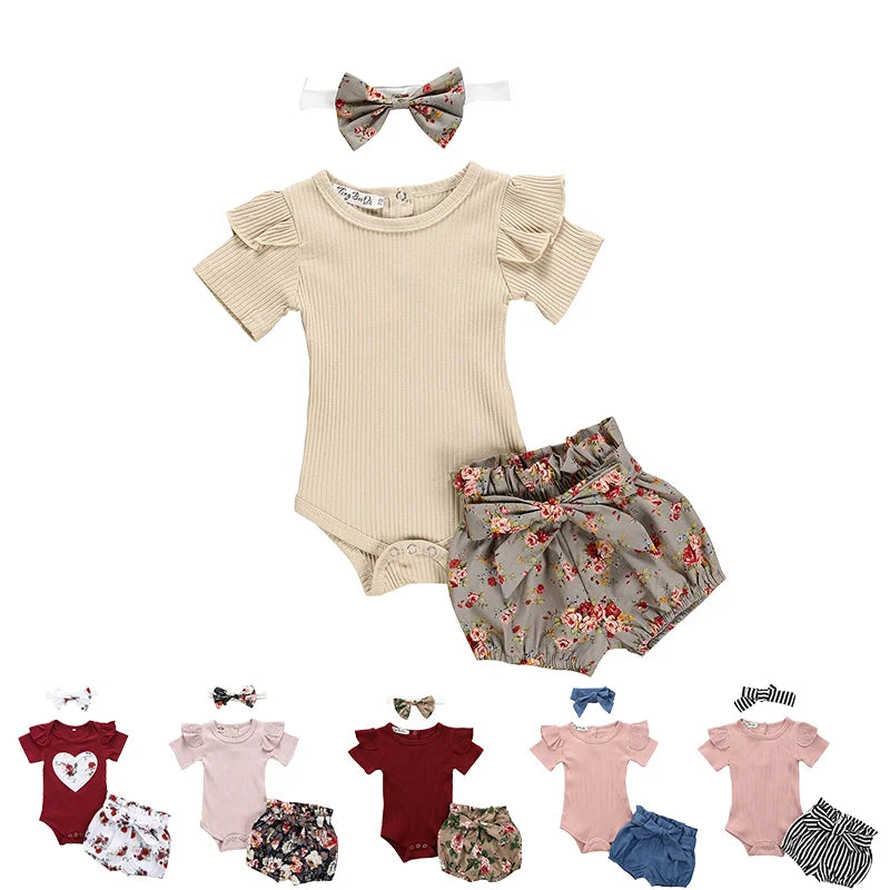 Baby outfit set with beige romper, floral shorts, and headband on a white background.