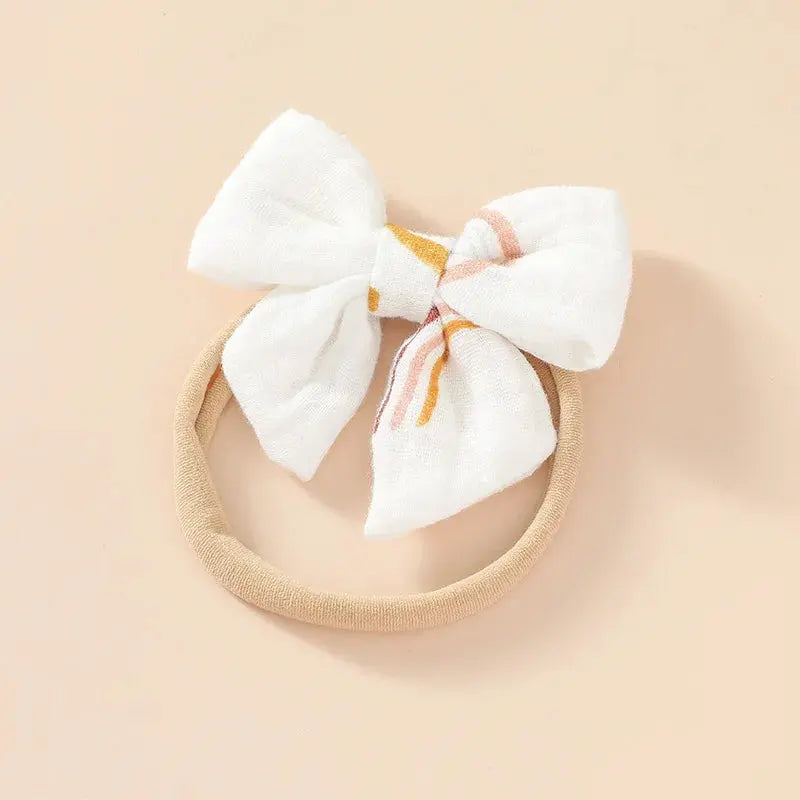 Beige headband with a large white bow on a beige background