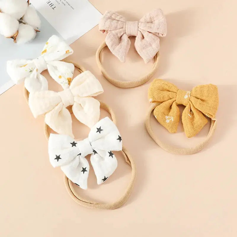 Set of baby headbands with decorative bows on a beige background