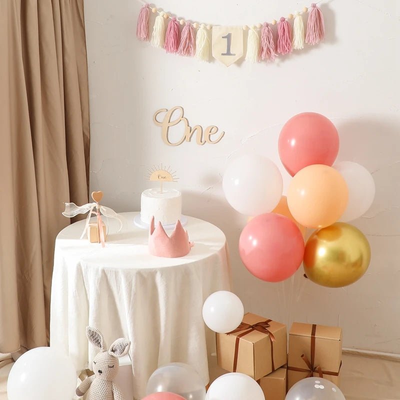 First birthday party setup with balloons, cake, and decorations.