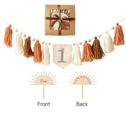 Decorative tassel garland with a banner and two wooden cake toppers on a white background.