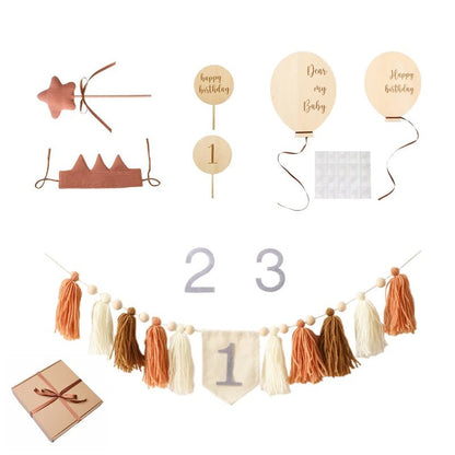 Collection of birthday-themed decorations including a star, crown, balloons, numbers, and tassel garland.