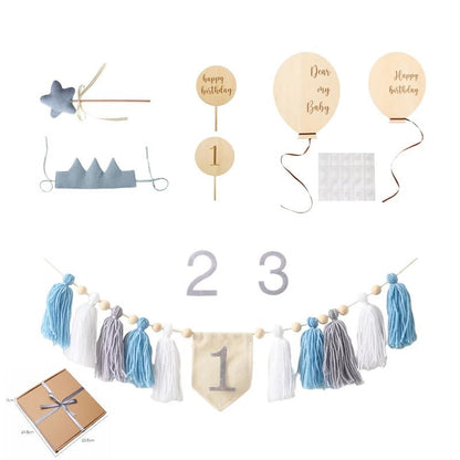 Collection of baby shower decorations including balloons, numbers, and tassel garland on a white background.