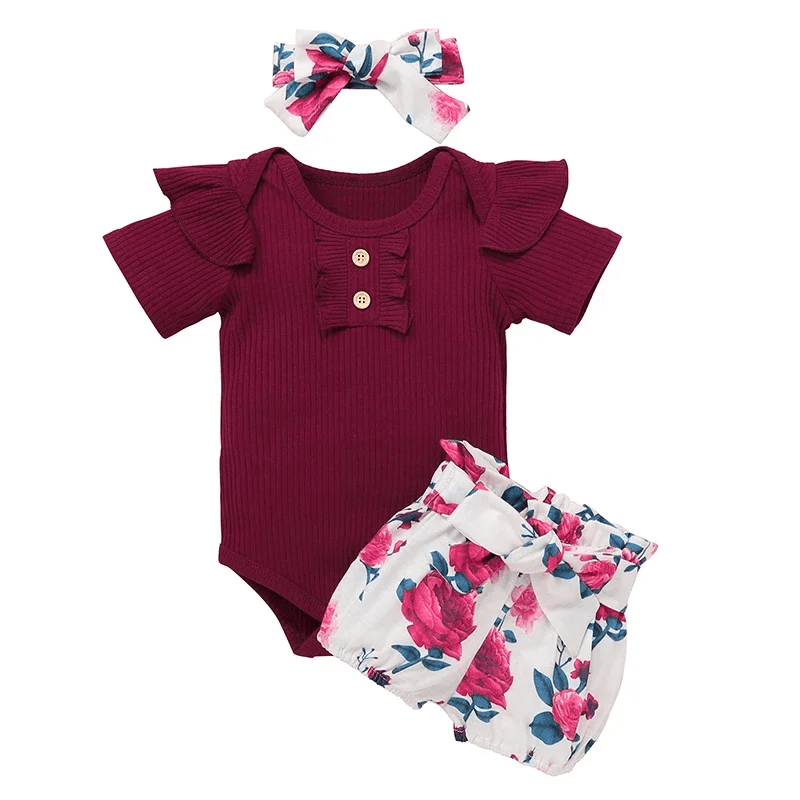 Baby outfit set with burgundy romper, floral bloomers, and headband on a white background