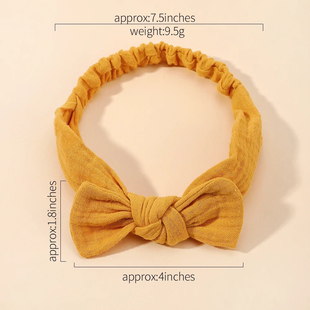 Yellow headband with a bow, shown with measurements on a beige background