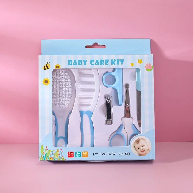 Baby grooming kit in retail packaging, including a brush, comb, nail clipper, and nail scissors, shown against a pink background.