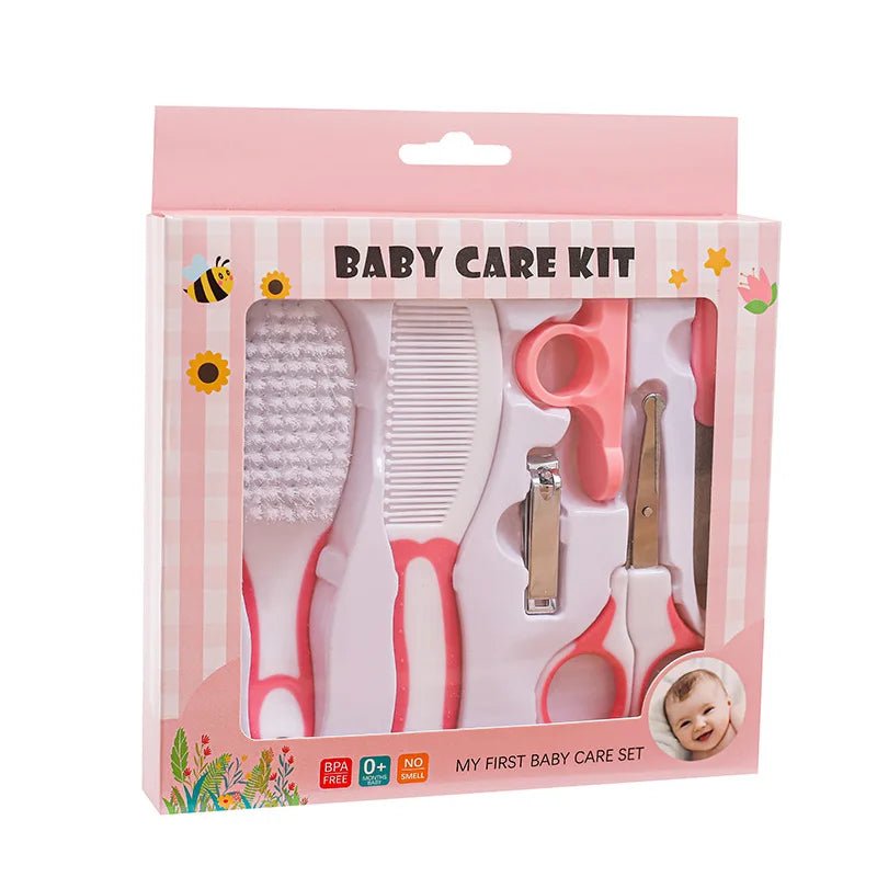 Baby grooming kit in pink striped retail packaging, containing a brush, comb, nail clipper, ear cleaner, and nail file.