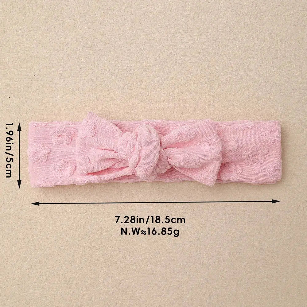 Pink textured headband with measurements on a beige background