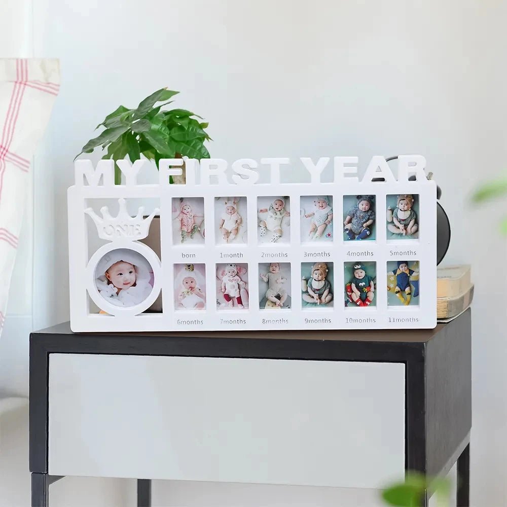 Collage of baby photos in a decorative frame on a white surface with a plant in the background.